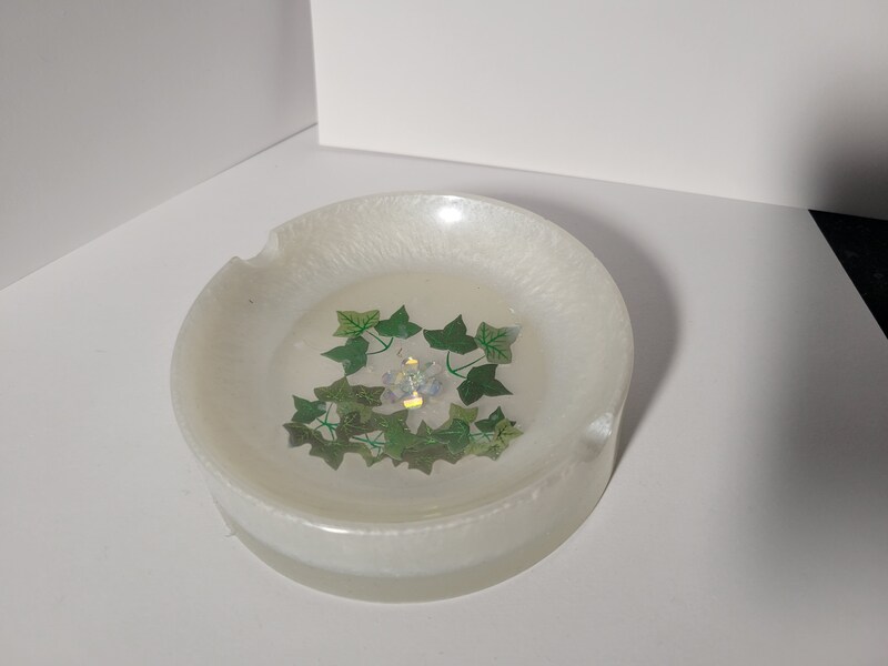 White ashtray bowl with ivy and a small flower